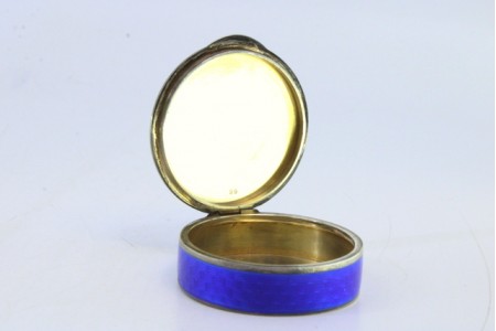 Caixa de comprimidos em prata esmaltada na tampa e envolvência e interior dourado.